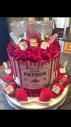 a fancy cake with strawberries and liquor bottles