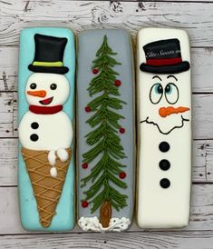 three decorated cookies in the shape of snowmen