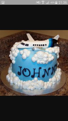 a birthday cake with an airplane and clouds on it