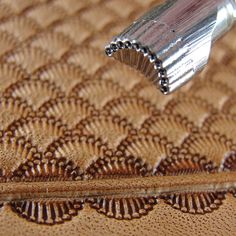 a close up view of a pen on a brown surface with intricate designs and lines