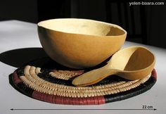 a wooden bowl and spoon sitting on top of a place mat