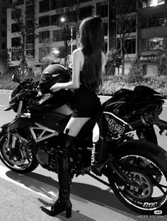 a woman sitting on top of a motorcycle