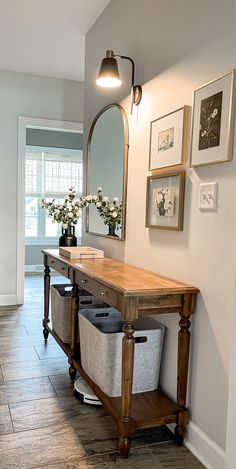 a wooden table sitting under a mirror in a room