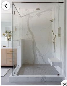 a white bathroom with marble floors and walls