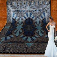 a person standing next to a blue and black carpet with an ornate design on it