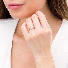 a woman wearing a white shirt and diamond ring