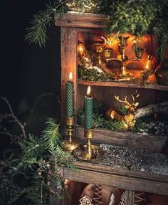 a christmas display with candles, ornaments and other things on it's shelf in the dark