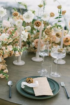 a table set with flowers, candles and napkins for an elegant wedding reception in the garden