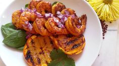 a white bowl filled with grilled oranges and onions next to a dandelion