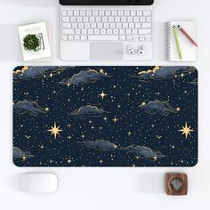 a computer mouse pad with stars and clouds in the night sky on top of a desk