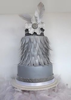 a three tiered cake decorated with feathers and flowers