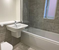 a white toilet sitting next to a bath tub