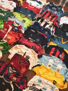 many soccer jerseys are laid out on the floor