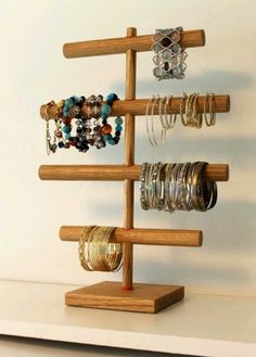 a wooden jewelry rack with bracelets and rings on it