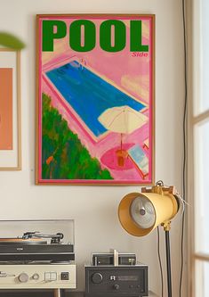 an old record player sits in front of a pool poster on the wall above it