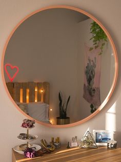 a mirror that is on the wall above a dresser