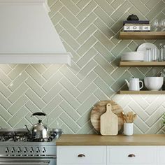 a stove top oven sitting inside of a kitchen next to a wall covered in shelves