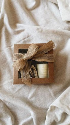 an open box with a candle inside on a bed