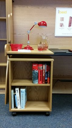 a book shelf with books and a lamp on top