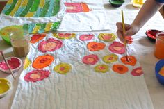 a child painting flowers on a piece of paper