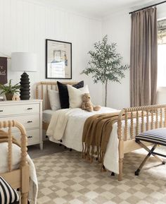 a bed room with a neatly made bed and a teddy bear sitting on the bed