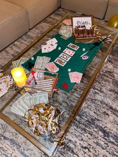 a glass table topped with lots of cards and other items next to a couch in a living room