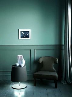 a chair and table in a room with green walls