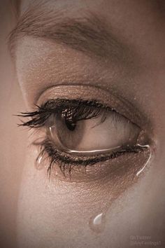 a woman's eye with water drops on the iris and her reflection in it