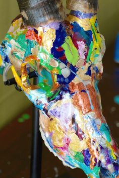 a cow's head is covered in colorful paint and paper mache, as well as other things