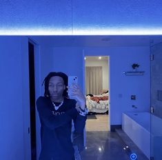 a woman taking a selfie in the mirror with her cell phone and lights on