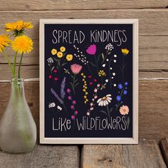 a vase filled with yellow flowers next to a sign that says spread kindness like wildflowers