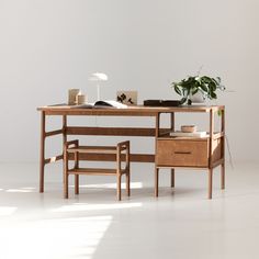 a wooden desk with two chairs and a plant