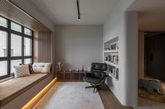 a living room with a window seat next to a book shelf