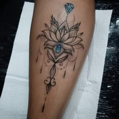 a woman's leg with a flower and diamond tattoo on the side of her leg