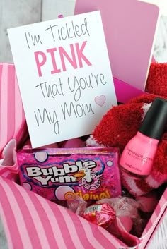 a pink gift box filled with candy, candies and a sign that says i'm tickled pink that you're my mom