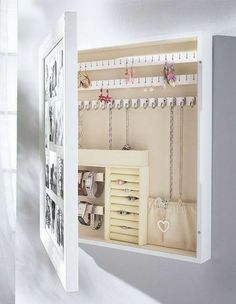 an open white door with jewelry hanging from it's sides and pictures on the wall