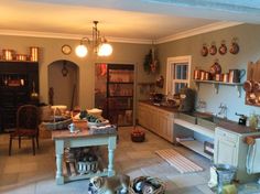 a dog laying on the kitchen floor in front of a table with food and utensils