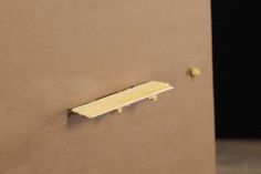 a piece of paper that has been pinned to a wall with a metal bar on it