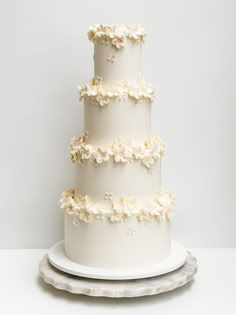 a three tiered white cake with flowers on it