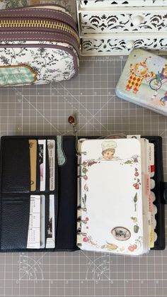 an open wallet sitting on top of a table next to other purses and papers