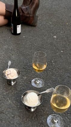 three wine glasses with ice cream in them sitting on the ground