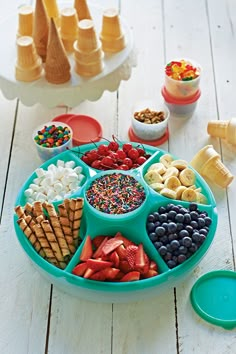 an ice cream sundae tray filled with fruit, cereals, and other treats