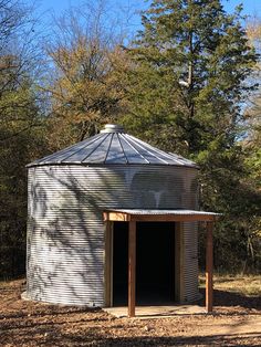 an outhouse in the middle of a wooded area