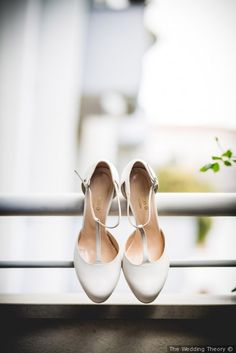 two pairs of white shoes sitting on top of a window sill