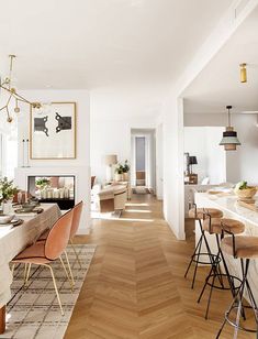 a dining room and kitchen area with wood flooring, white walls and wooden floors