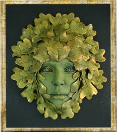 a woman's face with leaves on her head is shown in gold and green