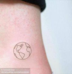 a small tattoo on the back of a woman's left leg, depicting the earth