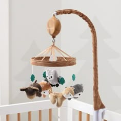 a baby crib with stuffed animals hanging from it's sides and a wooden pole in the background