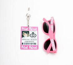 a pair of pink sunglasses with a keychain attached to it and an id card