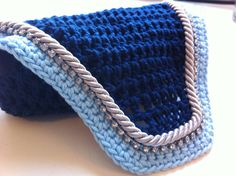 a blue and white crocheted bag sitting on top of a table